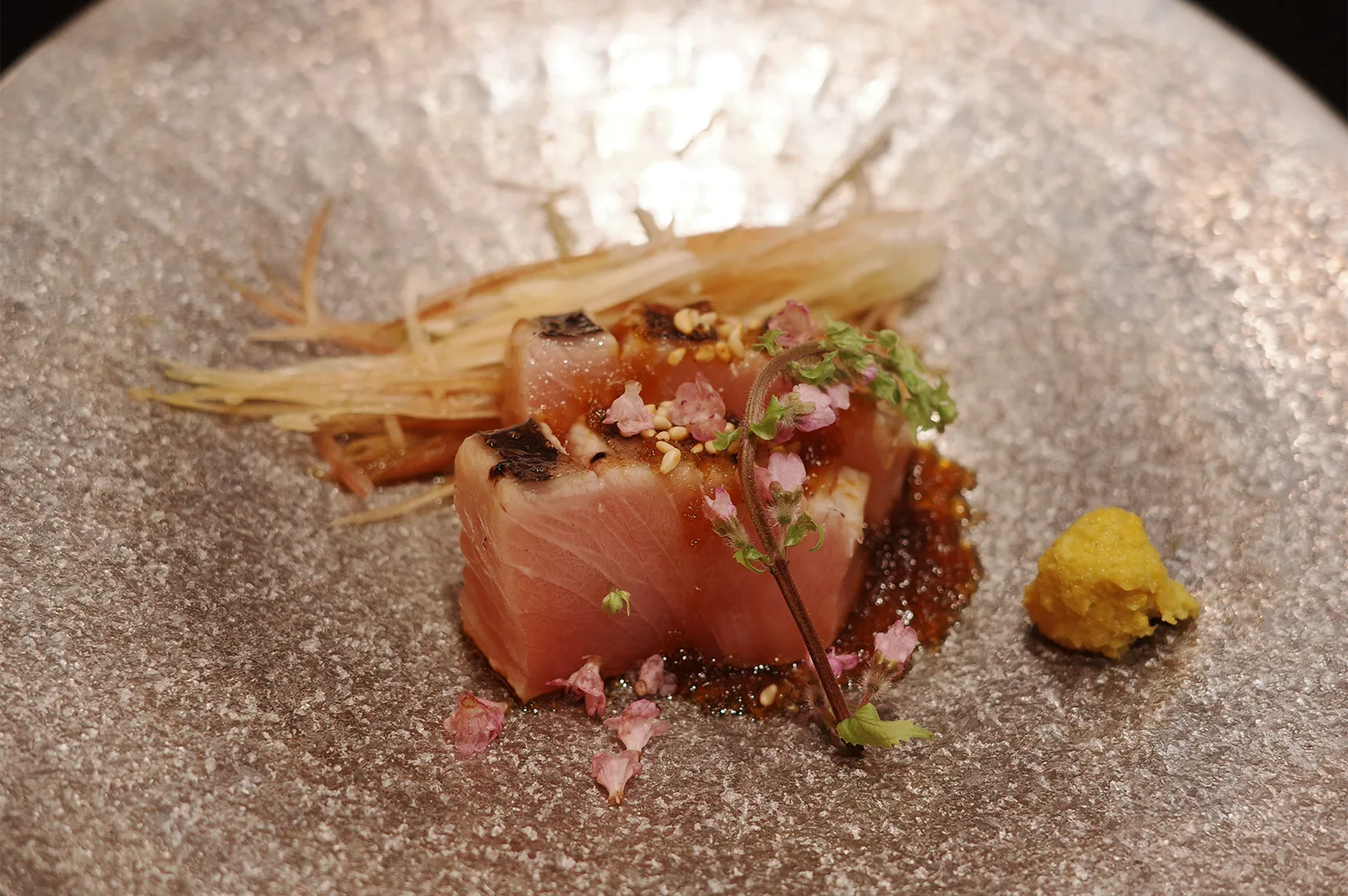 The elegant wooden exterior and glowing signage of a high-end Japanese omakase sushi restaurant.