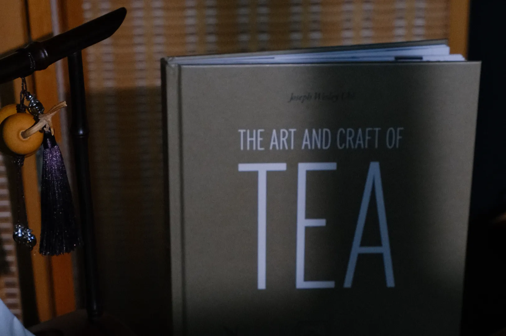 A book titled "The Art and Craft of Tea" is partially visible, with a tea-themed accessory beside it.