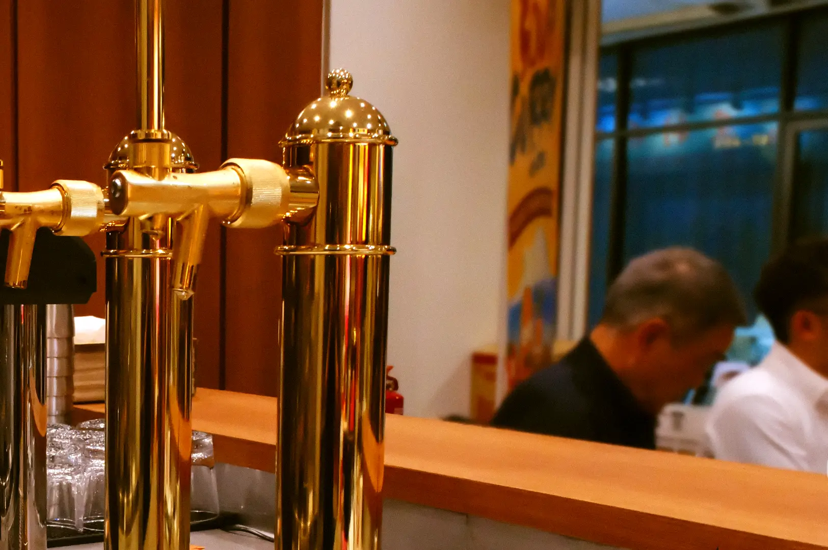 Close-up of two polished brass draught lines at the wooden bar counter of Craft Beer by Ki-setsu in Fortune Centre.