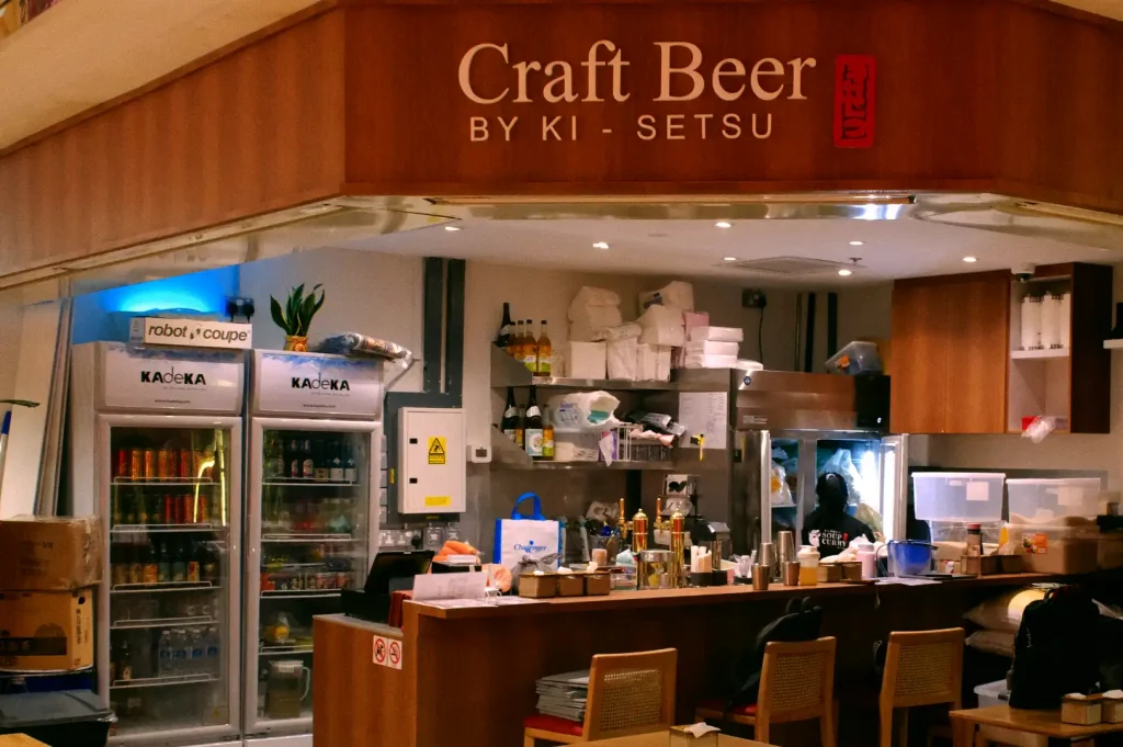 Open counter view of Craft Beer by Ki-setsu after dinner services, featuring tables cleared, the empty bar counter warmly lit by the overhead lighting inside Fortune Centre.